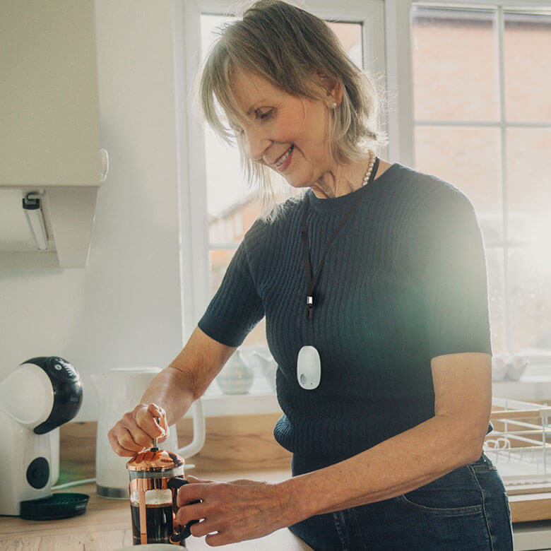 Woman making coffee in a kitchen.
